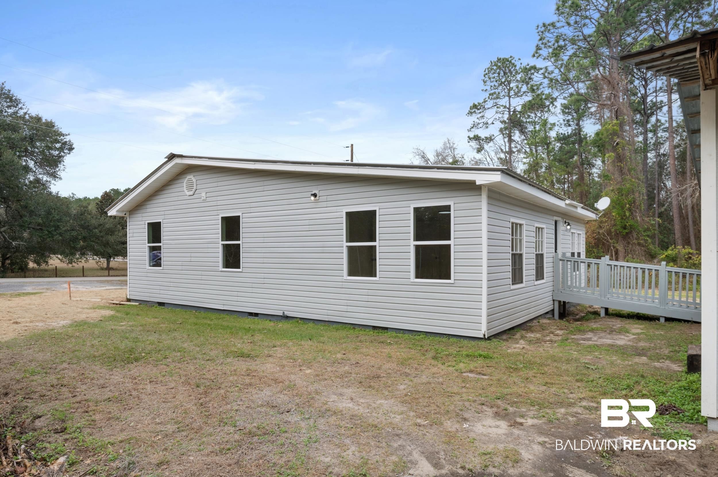 35780 Spring Road North Stapleton, AL 36578 - Photo 38 of 41 View of side of home with crawl space, a wooden deck, and a lawn