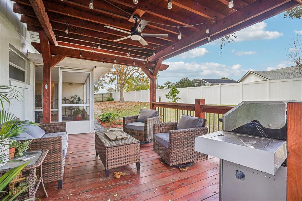 2052 Onecco Court Clermont, FL 34714 - Photo 25 of 33 a view of a patio with couches chairs potted plants and wooden floor