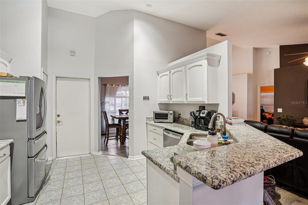 2052 Onecco Court Clermont, FL 34714 - Photo 9 of 33 a kitchen with stainless steel appliances granite countertop a sink refrigerator and cabinets
