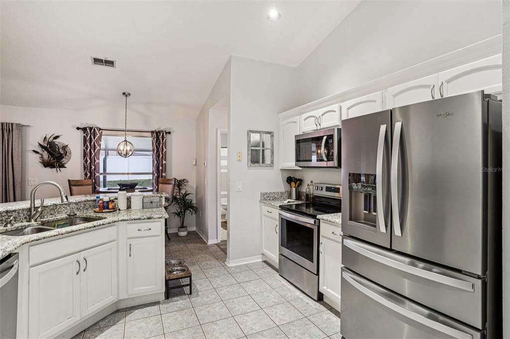 2052 Onecco Court Clermont, FL 34714 - Photo 10 of 33 a kitchen with a refrigerator sink and stainless steel appliances