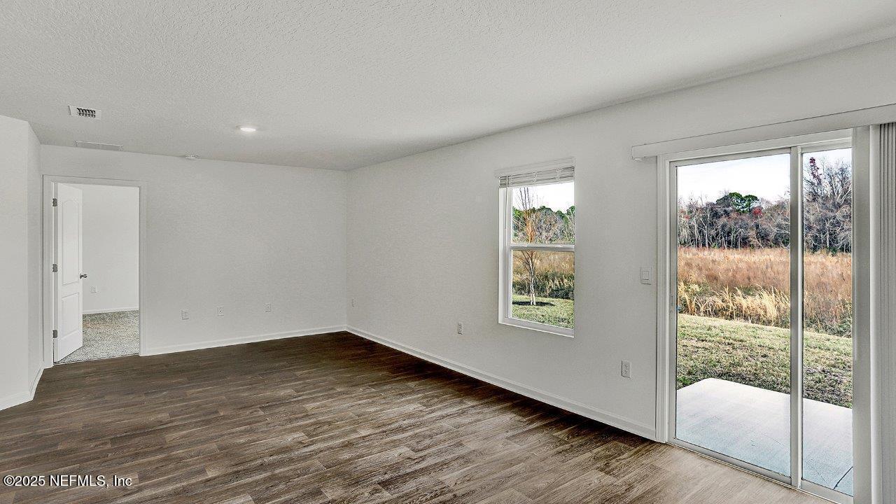 5645 Rustic Thorn Road Jacksonville, FL 32219 - Photo 5 of 45 an empty room with wooden floor and windows