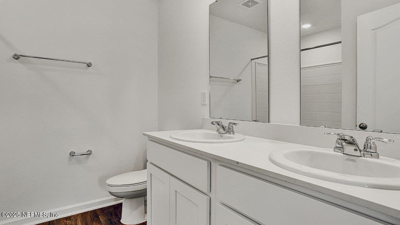 5645 Rustic Thorn Road Jacksonville, FL 32219 - Photo 8 of 45 a bathroom with a granite countertop sink a toilet and a mirror