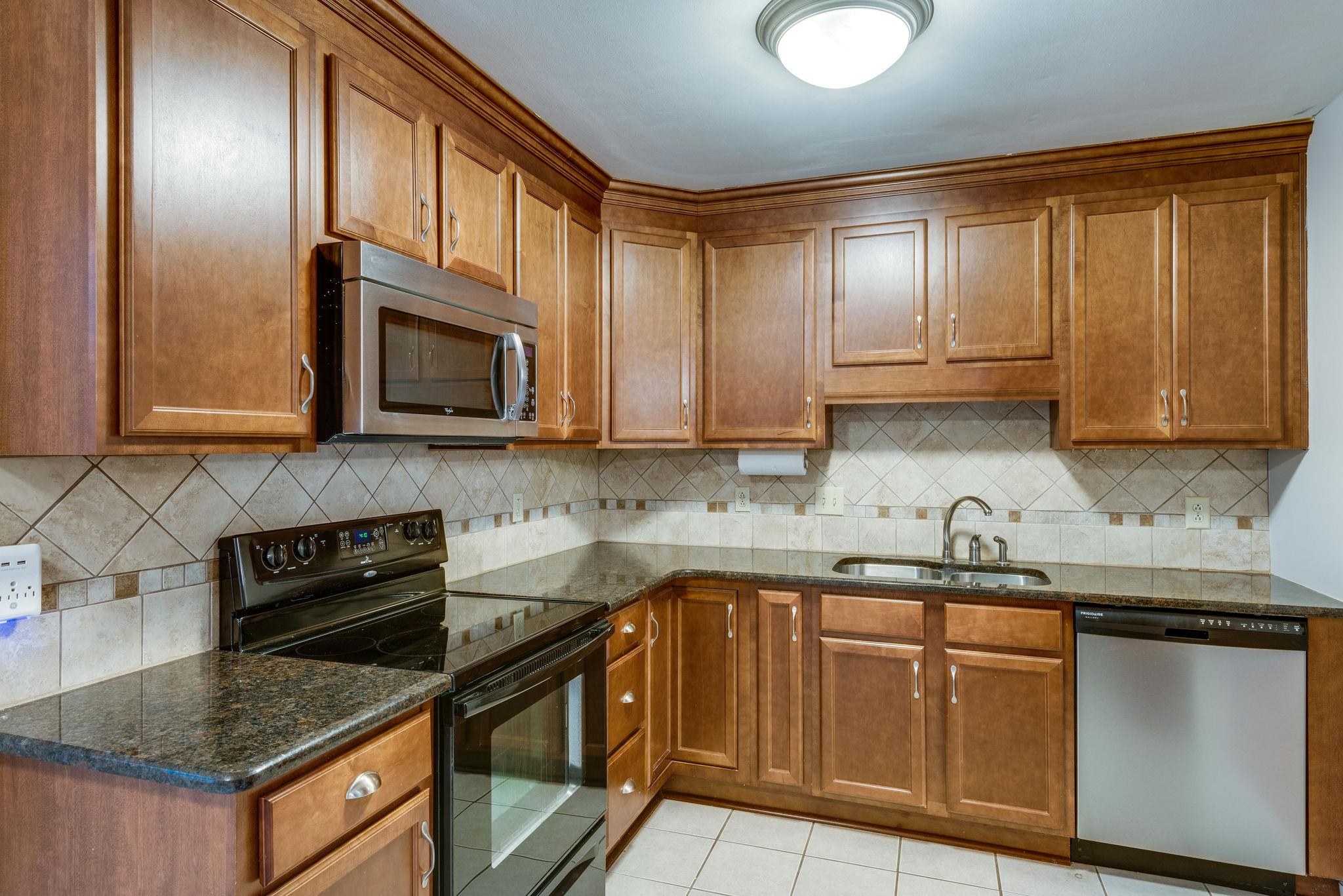 1012 General George Patton Road Nashville, TN 37221 - Photo 11 of 28 a kitchen with stainless steel appliances granite countertop wooden cabinets a stove top oven a sink and dishwasher
