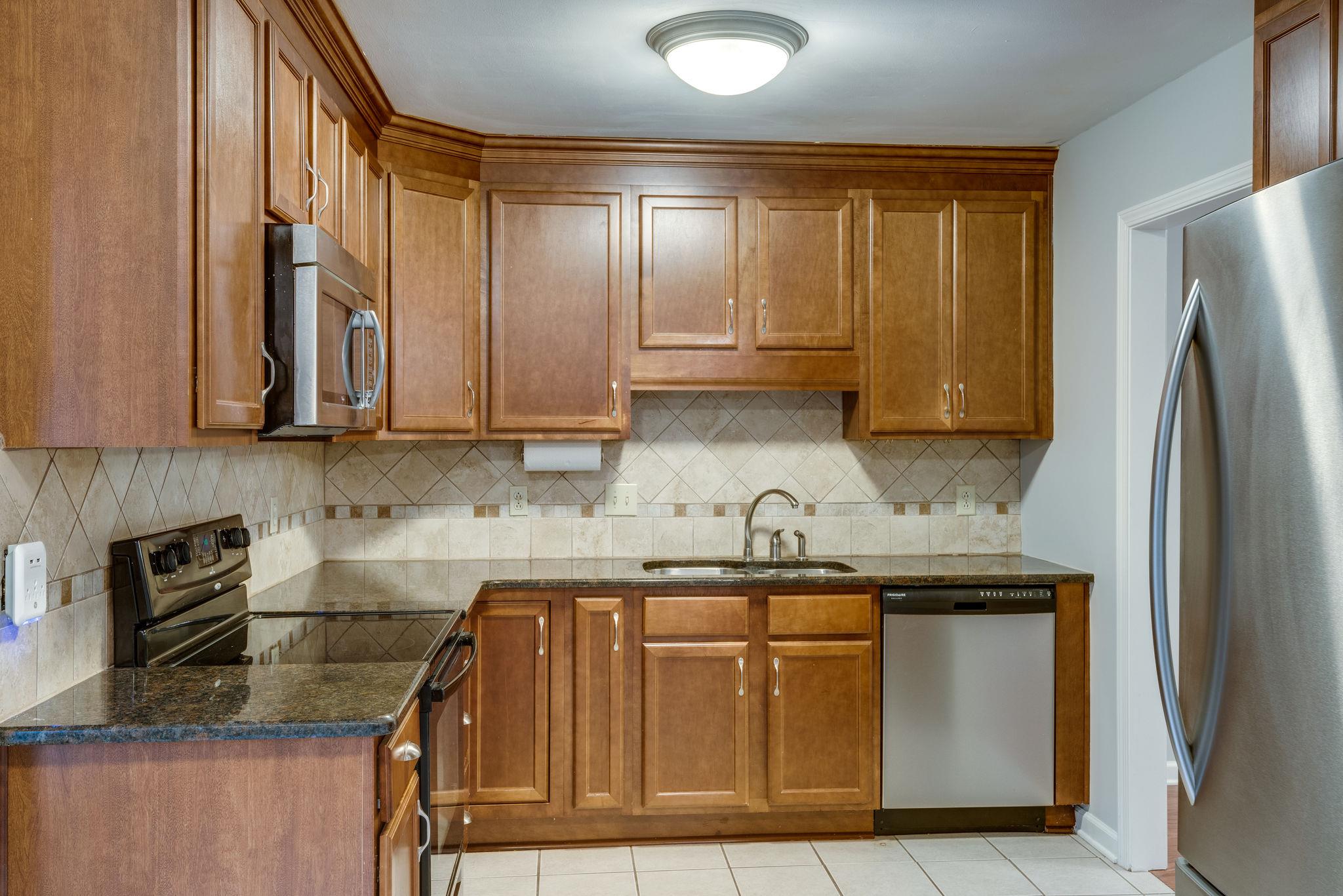 1012 General George Patton Road Nashville, TN 37221 - Photo 9 of 28 a kitchen with stainless steel appliances granite countertop a sink a stove and a refrigerator