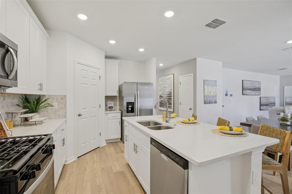 28005 Poppy Court Leesburg, FL 34748 - Photo 20 of 54 a kitchen that has a lot of cabinets a sink and appliances in it