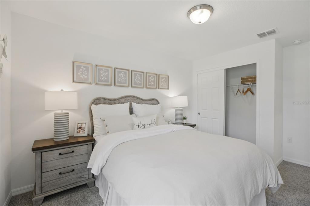 28005 Poppy Court Leesburg, FL 34748 - Photo 27 of 54 a bedroom with a bed and a chandelier