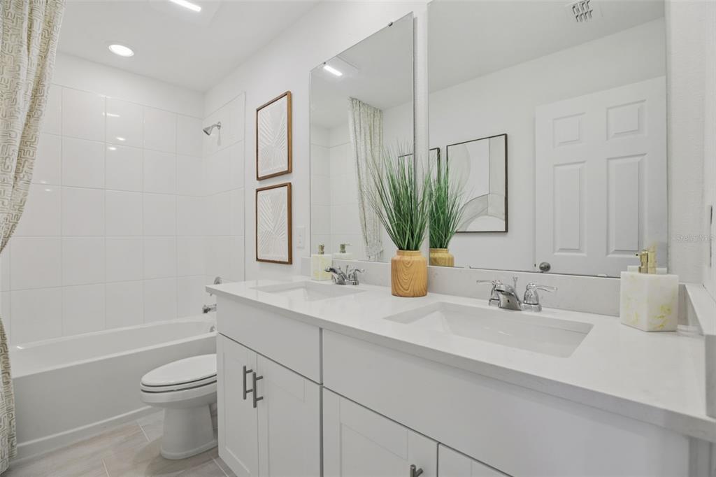 28005 Poppy Court Leesburg, FL 34748 - Photo 28 of 54 a bathroom with a granite countertop sink toilet a large mirror and shower