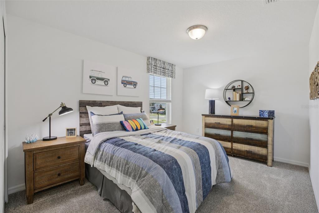 28005 Poppy Court Leesburg, FL 34748 - Photo 31 of 54 a bedroom with a bed and a chandelier