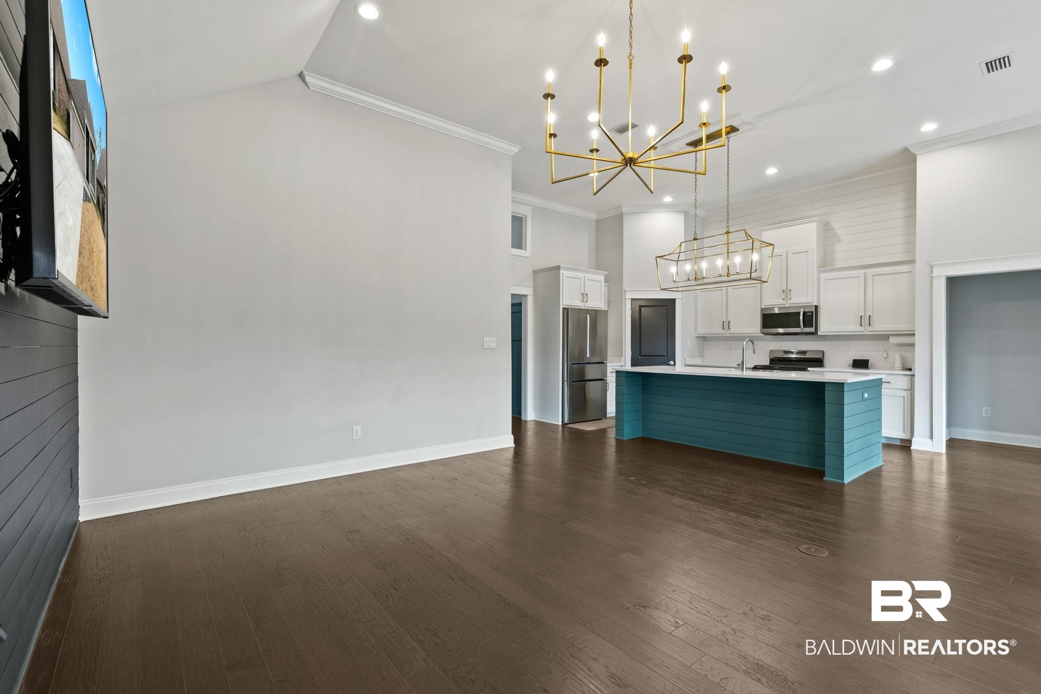 31654 Canopy Loop Daphne, AL 36527 - Photo 11 of 64 Kitchen featuring two tone color scheme, suspended lighting, crown molding, dark wood-style flooring, and a center island with sink