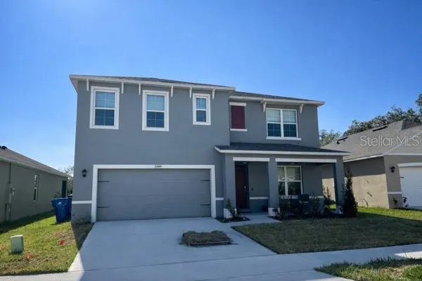 a front view of a house with a yard and garage