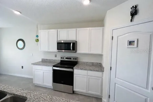 a kitchen with white cabinets and white appliances