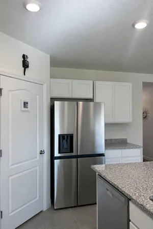 a kitchen with metallic refrigerator and sink