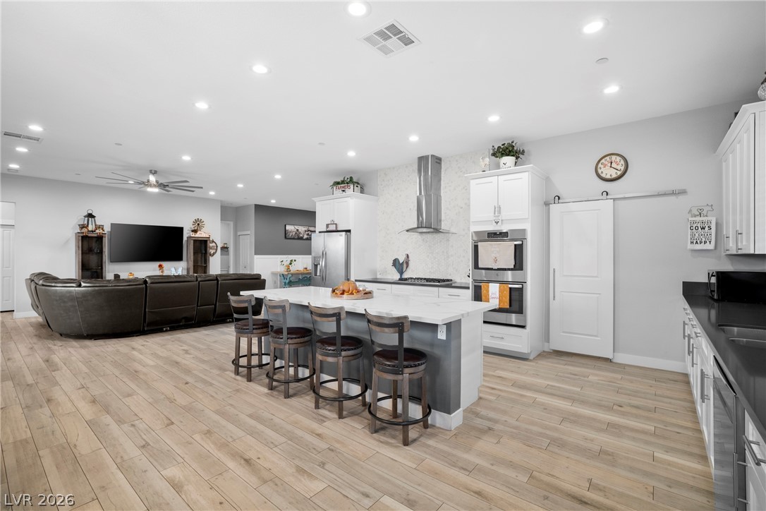 432 North Racetrack Road Henderson, NV 89015 - Photo 45 of 45 Kitchen with a kitchen island, a breakfast bar area, recessed lighting, open floor plan, and white cabinets