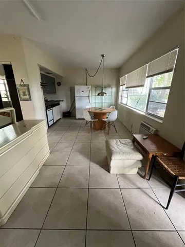 a patio with table and chairs and potted plants