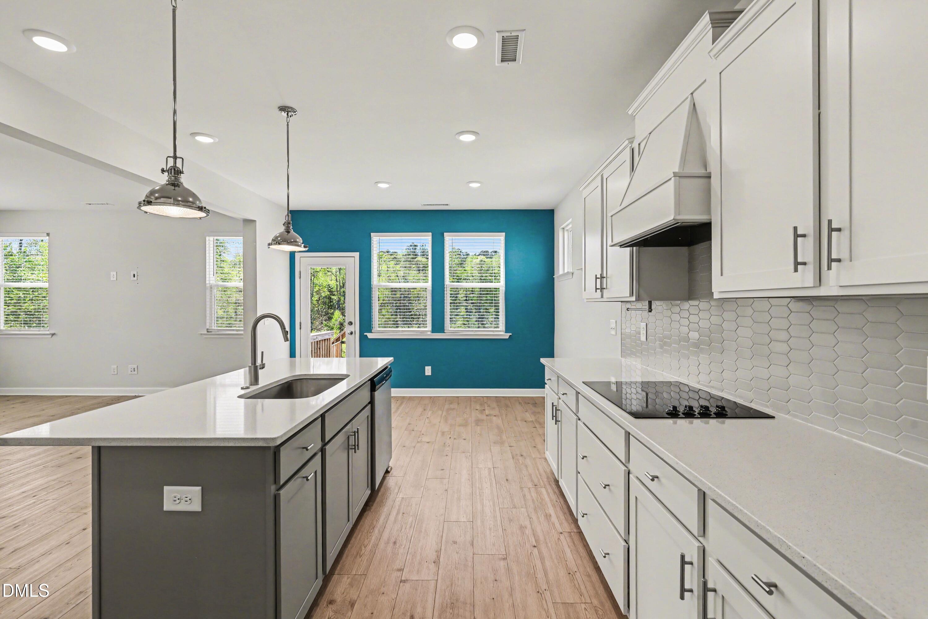 90 Rigsby Avenue Four Oaks, NC 27524 - Photo 21 of 43 a kitchen with stainless steel appliances granite countertop a sink a stove and a wooden floors