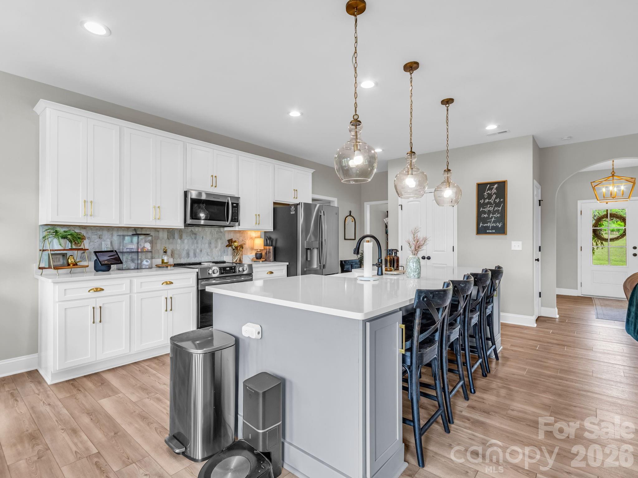 288 Maypole Court Forest City, NC 28043 - Photo 8 of 47 a kitchen with stainless steel appliances kitchen island granite countertop a table chairs and a refrigerator