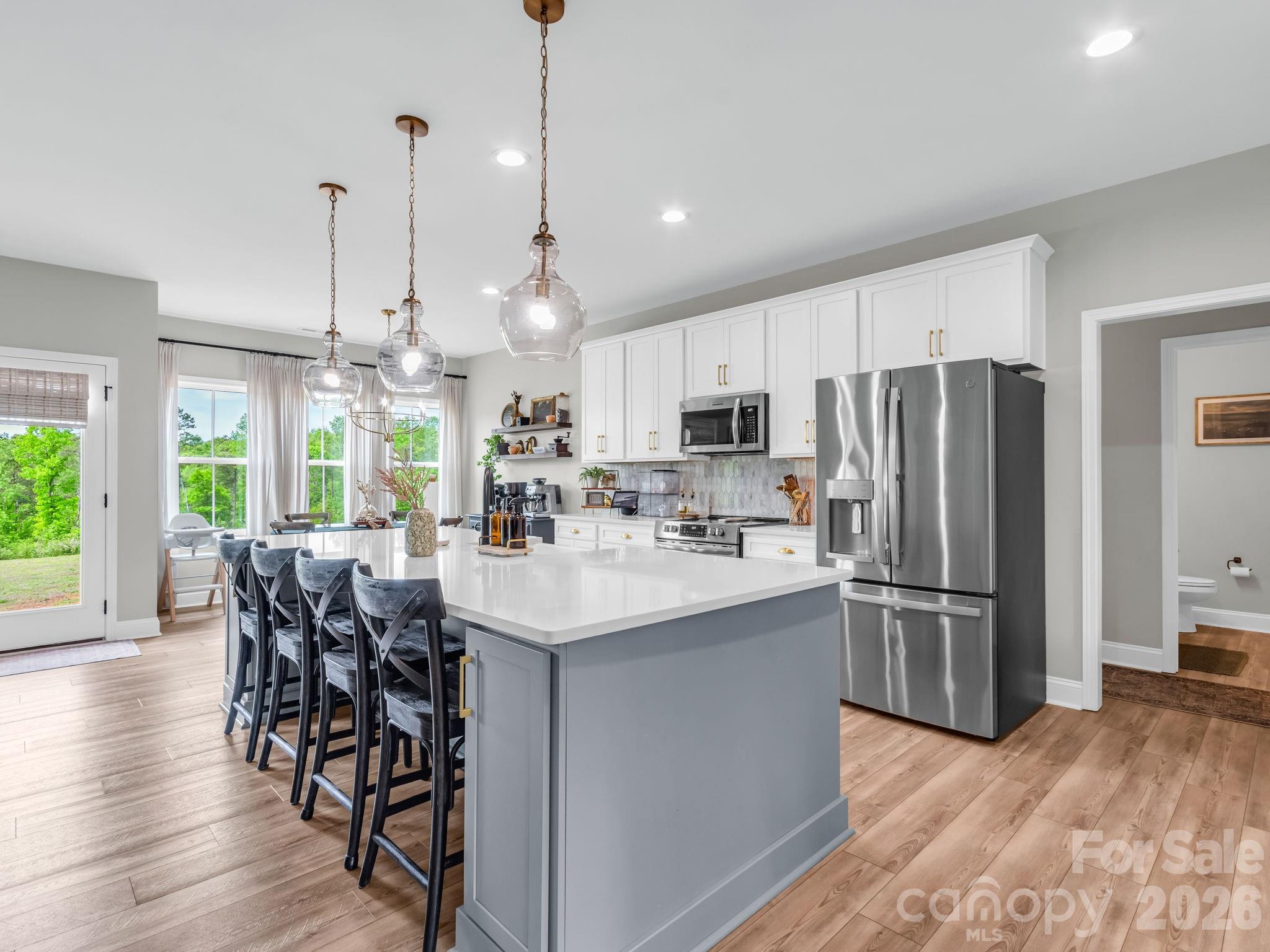 288 Maypole Court Forest City, NC 28043 - Photo 9 of 47 a kitchen with stainless steel appliances a dining table chairs refrigerator and microwave