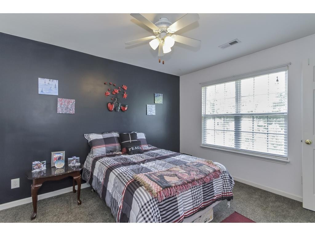 1223 Maple Burlington, NC 27217 - Photo 11 of 24 a bedroom with a bed and a chandelier