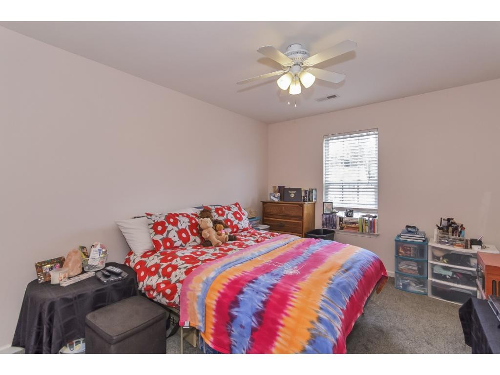 1223 Maple Burlington, NC 27217 - Photo 18 of 24 a bedroom with a bed window and a chandelier