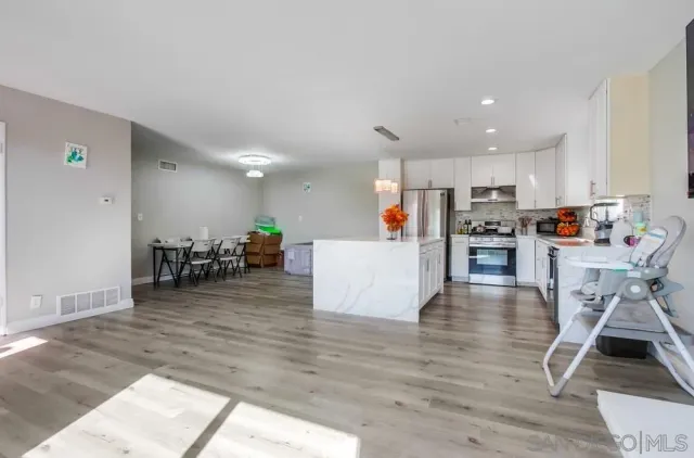 a kitchen with cabinets and wooden floor