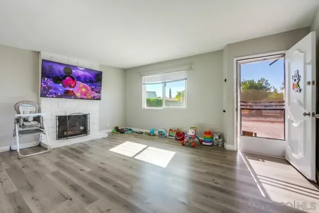 a kitchen with a refrigerator and a wooden floor