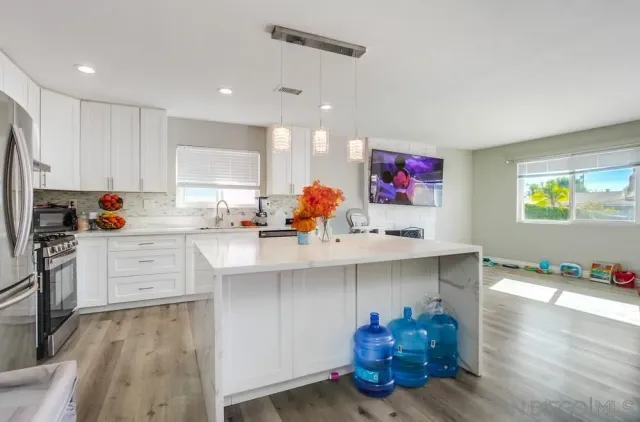 a kitchen with stainless steel appliances granite countertop a sink stove refrigerator and cabinets