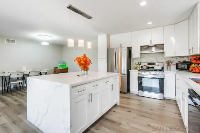 a kitchen with a sink cabinets and wooden floor