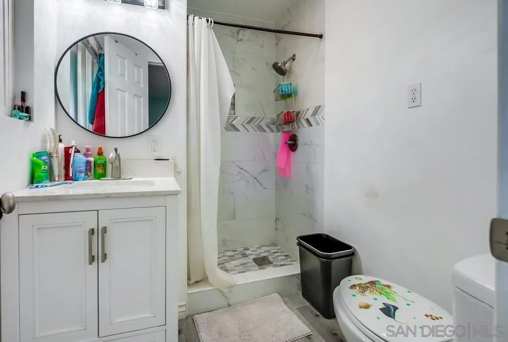 634 Daisy Street Escondido, CA 92027 - Photo 27 of 57 a bathroom with a toilet sink vanity and mirror