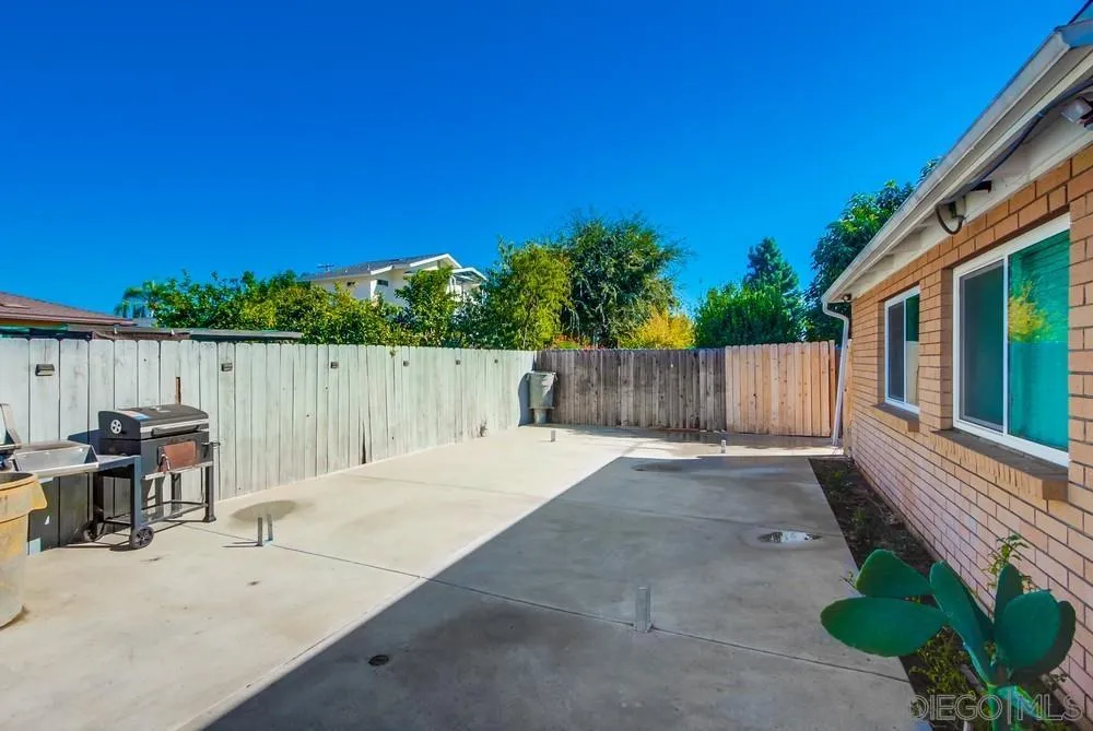 634 Daisy Street Escondido, CA 92027 - Photo 39 of 57 a backyard of a house with table and chairs a barbeque with wooden fence