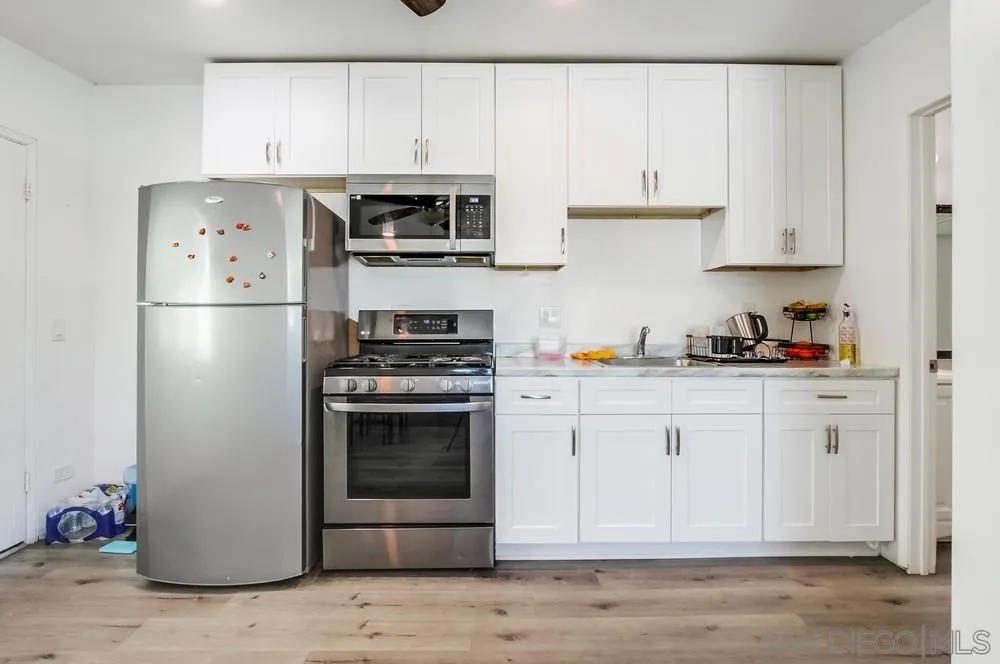 634 Daisy Street Escondido, CA 92027 - Photo 49 of 57 a kitchen with stainless steel appliances granite countertop a refrigerator stove and white cabinets