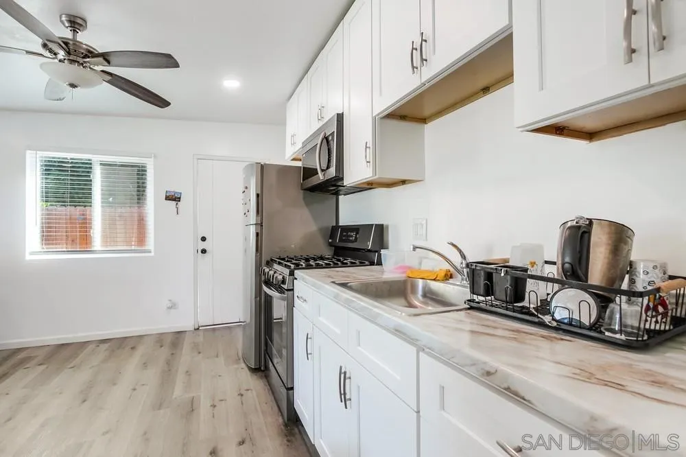 634 Daisy Street Escondido, CA 92027 - Photo 50 of 57 a kitchen with a sink dishwasher a stove and a refrigerator with wooden floor