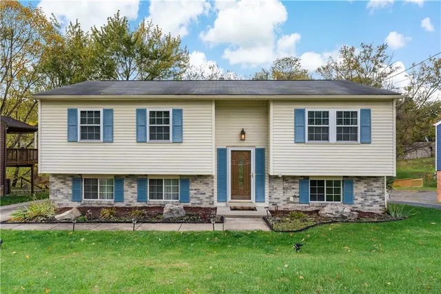 a front view of house with a garden and outdoor seating