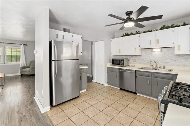 a kitchen with stainless steel appliances a refrigerator sink and wooden floor