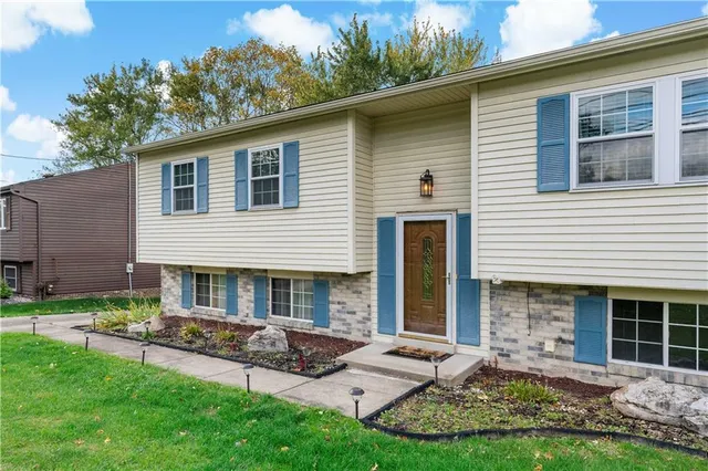 a view of house with a yard and porch