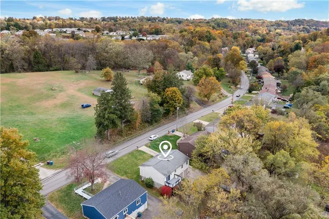an aerial view of lake residential house with outdoor space and trees around