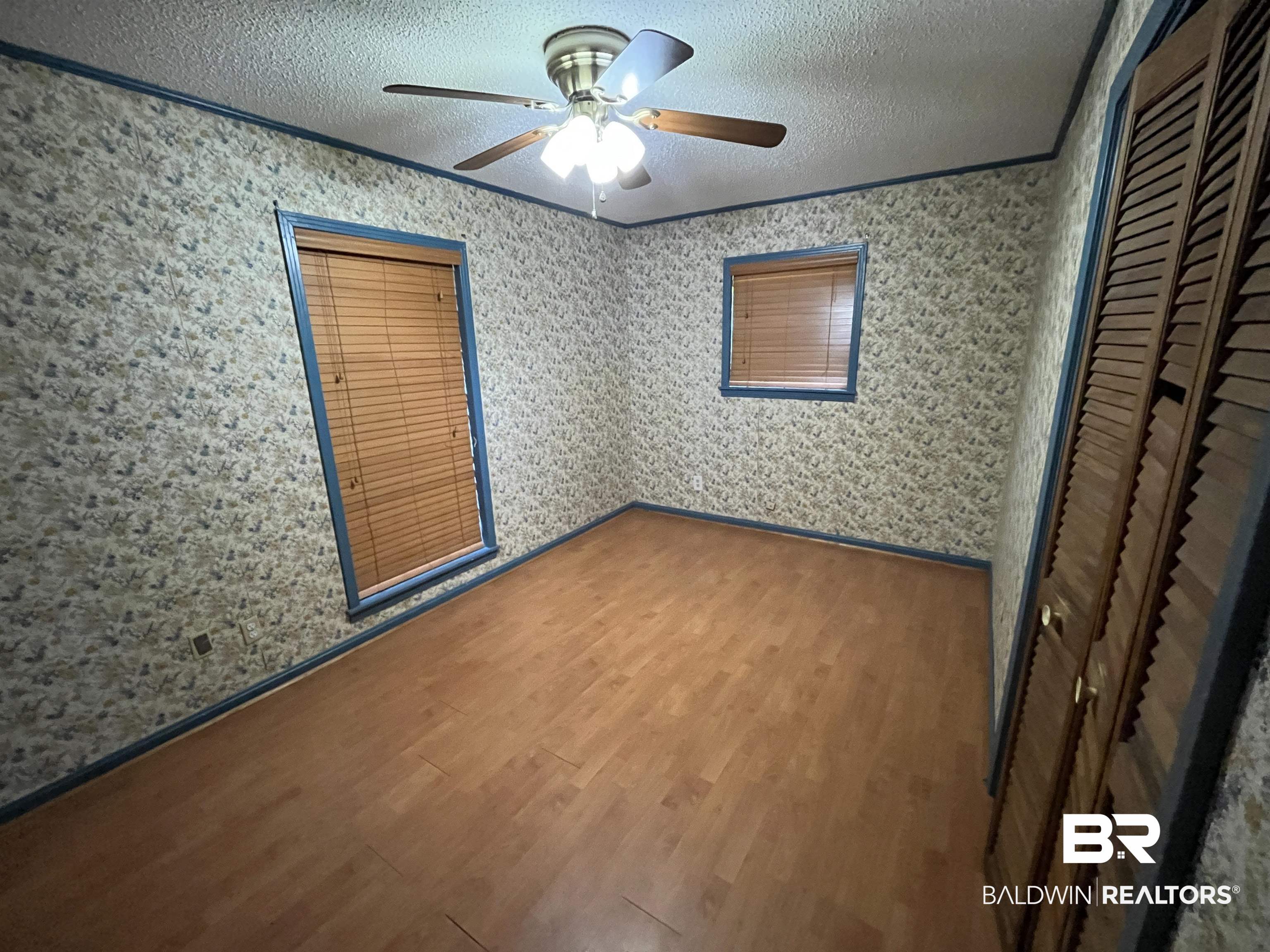 1905 Rockaway Creek Road Atmore, AL 36502 - Photo 23 of 23 Room featuring wood-finish flooring, two windows with blinds, and a ceiling fan