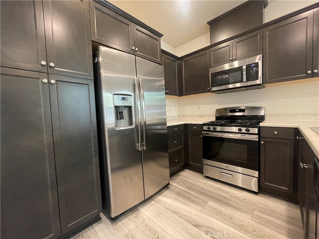 a kitchen with stainless steel appliances granite countertop a refrigerator and a stove