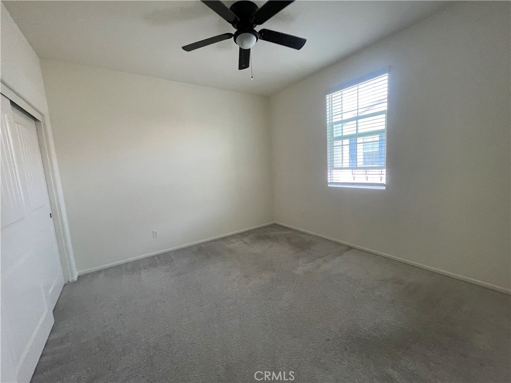 30360 Town Square Drive Menifee, CA 92584 - Photo 19 of 26 an empty room with a ceiling fan and window