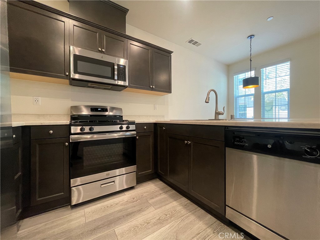 30360 Town Square Drive Menifee, CA 92584 - Photo 5 of 26 a kitchen with a sink stove and microwave