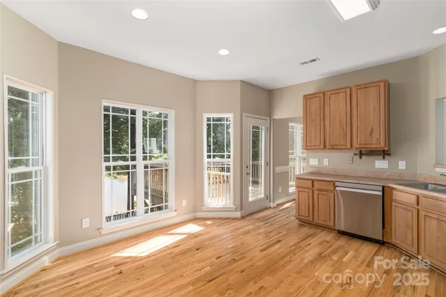 a large kitchen with stainless steel appliances granite countertop a sink and dishwasher with wooden floor