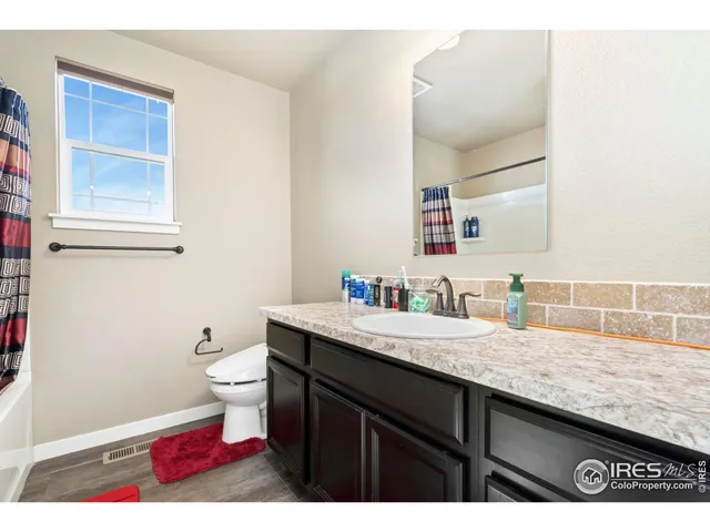 a bathroom with a granite countertop sink a toilet and a mirror