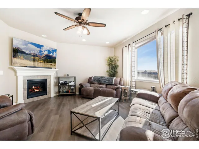 a living room with furniture a fireplace and a large window