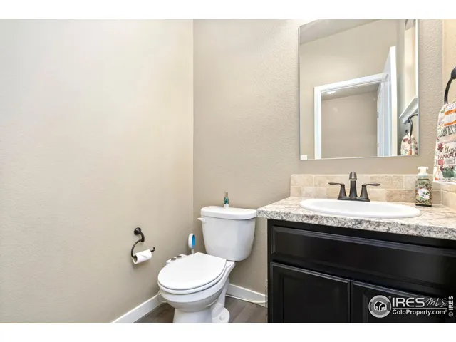 a bathroom with a granite countertop toilet sink and mirror