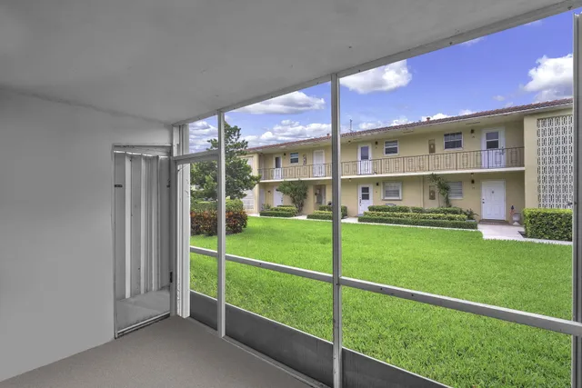a view of a house with a big yard and large trees