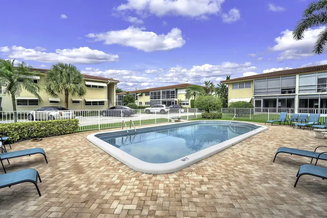 a view of a house with swimming pool and sitting area