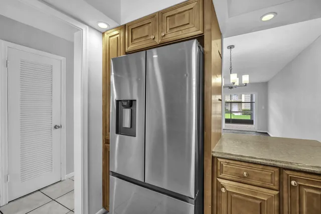 a metallic refrigerator freezer sitting inside of a kitchen