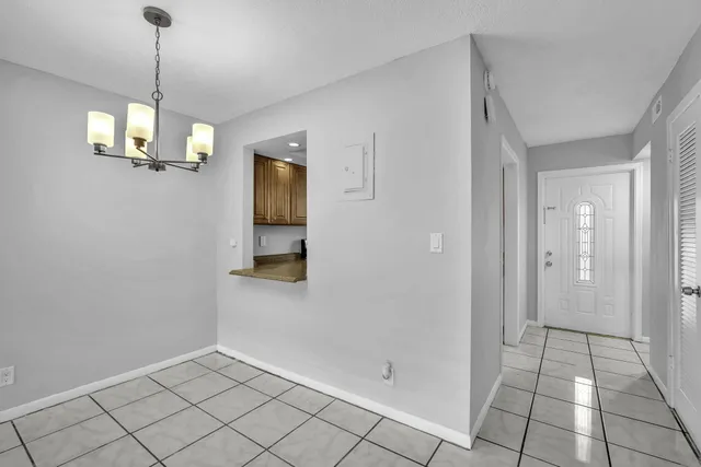 a view of a hallway with chandelier and entryway