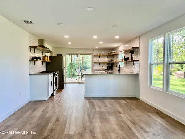 a kitchen with stainless steel appliances granite countertop a sink a stove and cabinets