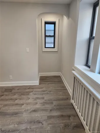 a view of a hallway with wooden floor and closet area
