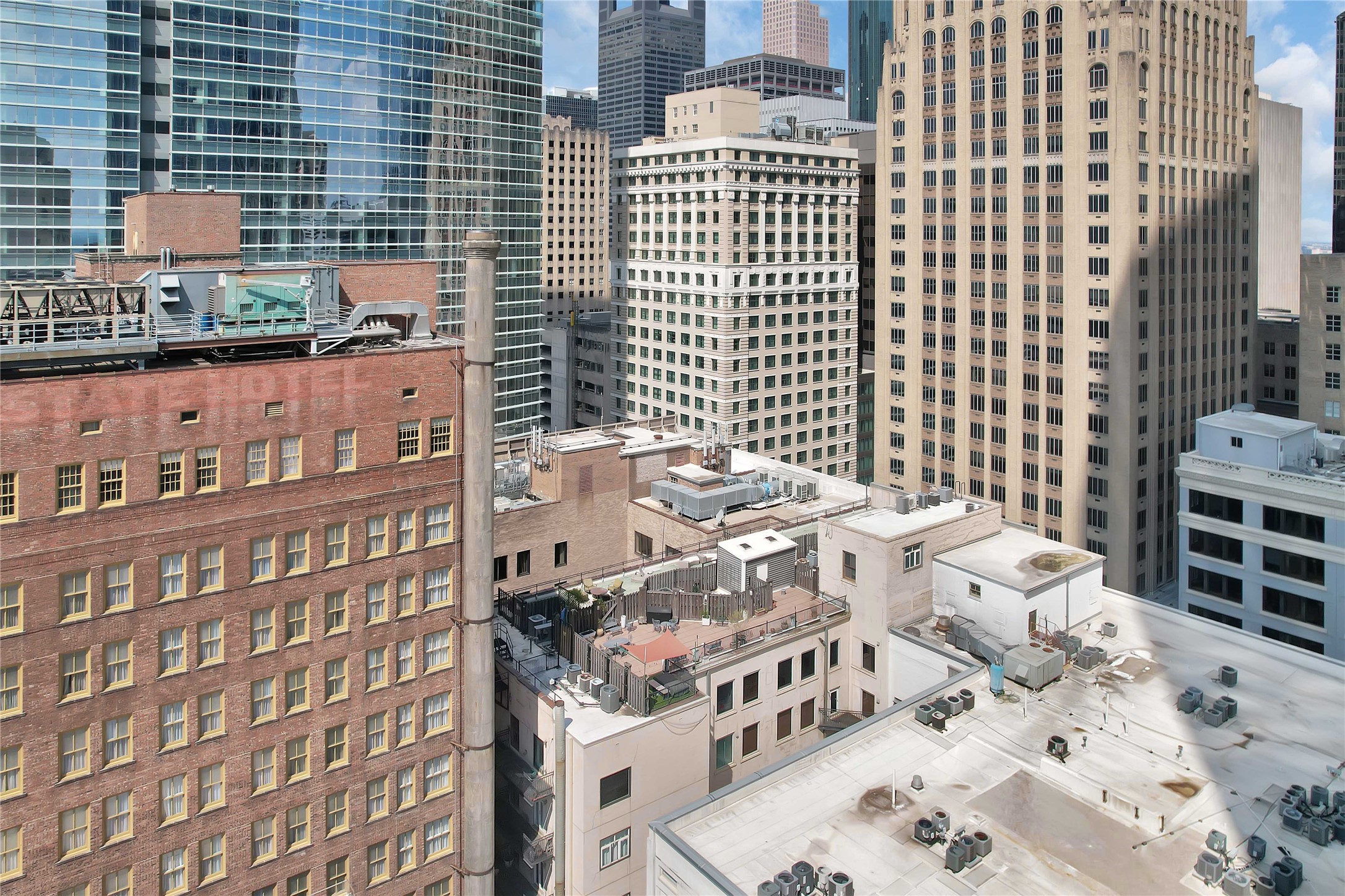 711 Main Street, Unit PH 1003 Houston, TX 77002 - Photo 29 of 32 Arial view of building roof and private rooftop terrace with surrounding buildings in downtown Houston.